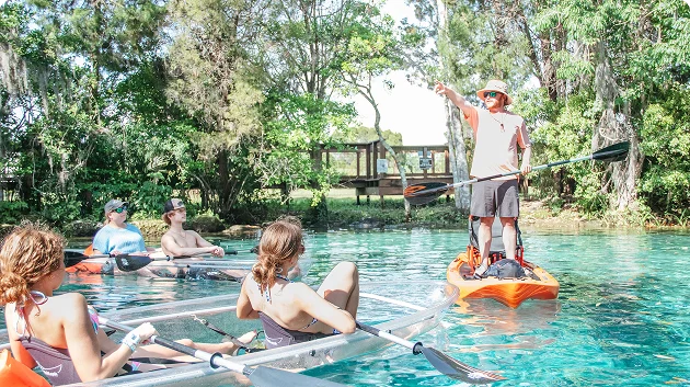 Outdoor adventure group enjoying a guided kayaking trip in a pristine natural spring